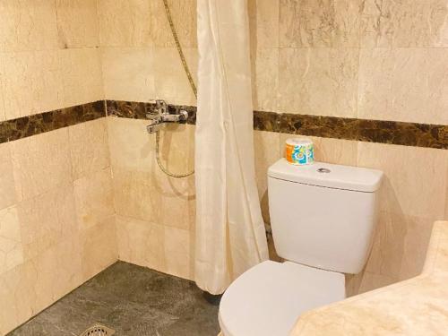 a bathroom with a toilet and a shower at Grand Verona Samarinda in Samarinda