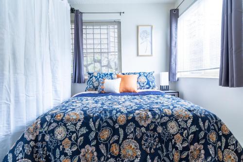 a bedroom with a bed with a blue floral bedspread at King Bed + Studio! Free Parking, Patio, WFH Space! in Seattle