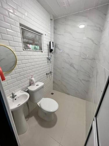 a white bathroom with a toilet and a sink at Rumah Aggrek@Zaki’s Residence, Marang, Terengganu in Kampong Ru Lima