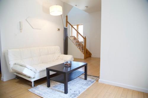 a living room with a white couch and a table at BrightonBeach-Spacious Room-Close to Beach in Brooklyn