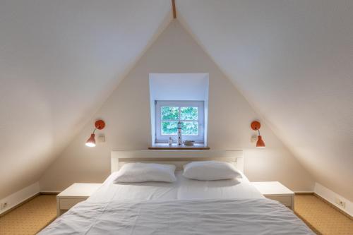 a bedroom with a white bed and a window at Kastanienhof Strandhafer in Wisch