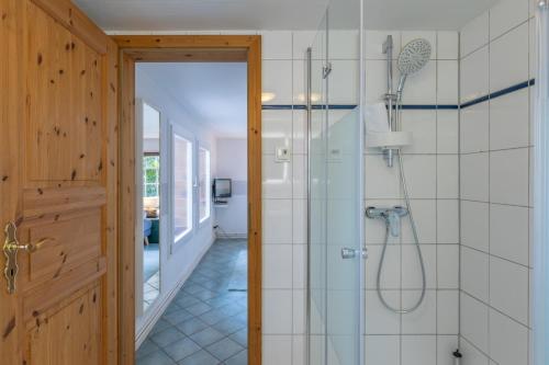 a bathroom with a shower and a glass door at Kastanienhof Strandhafer in Wisch