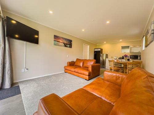 a living room with a couch and a kitchen at The Captains Motel in Russell