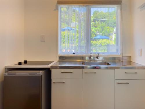 a kitchen with a sink and a window at The Captains Motel in Russell