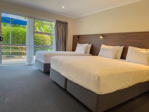 a bedroom with two beds and a large window at The Captains Motel in Russell