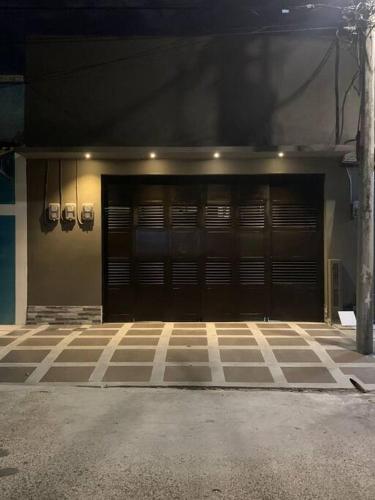 a garage with two sets of doors on a building at Apartamento de descanso in La Dorada
