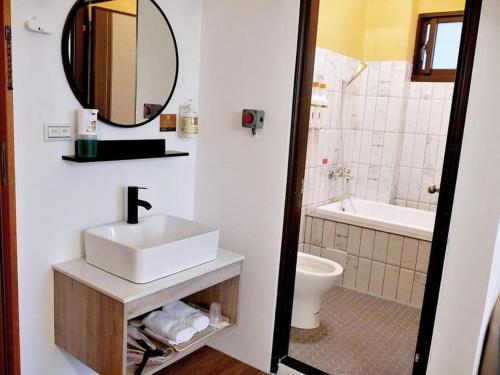 a bathroom with a sink and a toilet and a mirror at 充電樁 羅東好民宿Cloud BnB 3 雲朵朵3館 近週三清溝 免費洗衣機 烘衣機 星巴克咖啡豆 國旅特約店 in Yilan City