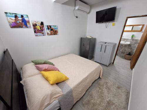 Dormitorio pequeño con cama con almohadas coloridas en Posada Cedar Valley, en Providencia