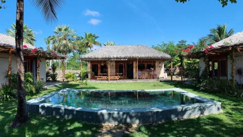 ein Haus mit einem kleinen Pool im Hof in der Unterkunft Casa Rosa Atins in Atins