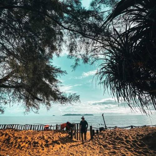 een man op het strand die naar de oceaan kijkt bij Rumah Melati@Zaki’s Residence, Marang, Terengganu in Kampong Ru Lima