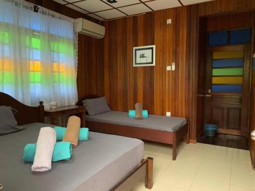 een slaapkamer met 2 bedden en een raam met regenboog bij Rumah Melati@Zaki’s Residence, Marang, Terengganu in Kampong Ru Lima