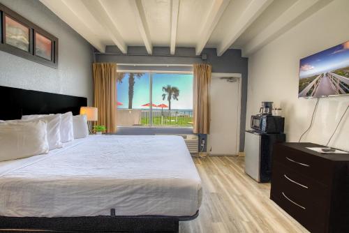 a bedroom with a bed with a view of the beach at Beach House Inn in Daytona Beach
