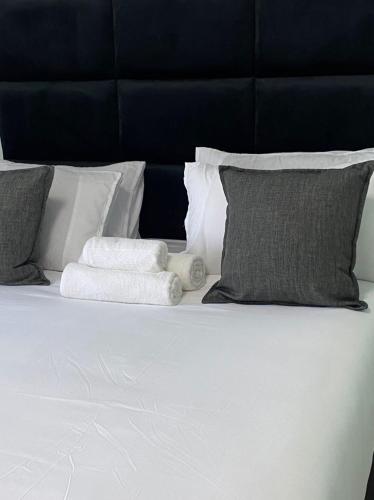 a white bed with pillows and towels on it at Stylish apartments in Gaborone