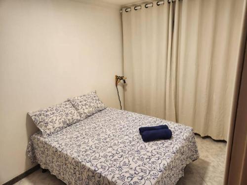 a bedroom with a bed with a blue pillow on it at Apartamento perto da Orla de Atalaia in Aracaju