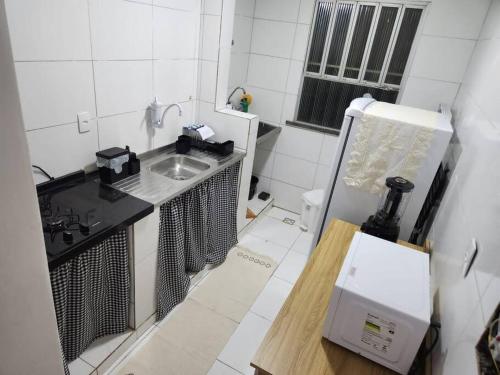 eine kleine Küche mit Spüle und Kühlschrank in der Unterkunft Apartamento perto da Orla de Atalaia in Aracaju