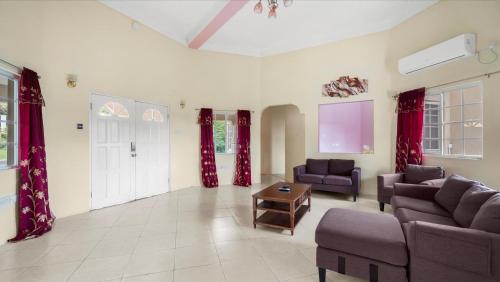 a living room with two couches and a table at Kaibus Place- Quaint Quiet and Cosy in Morne Rouge