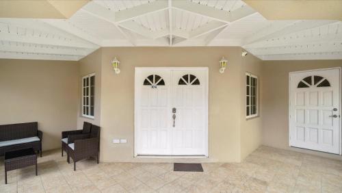 a room with a white door and a piano at Kaibus Place- Quaint Quiet and Cosy in Morne Rouge