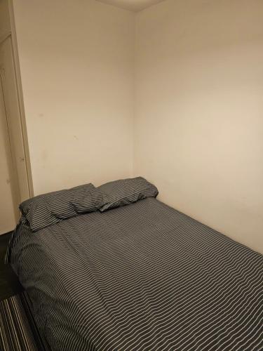 um pequeno quarto com uma cama num quarto em single room close to the city em Londres