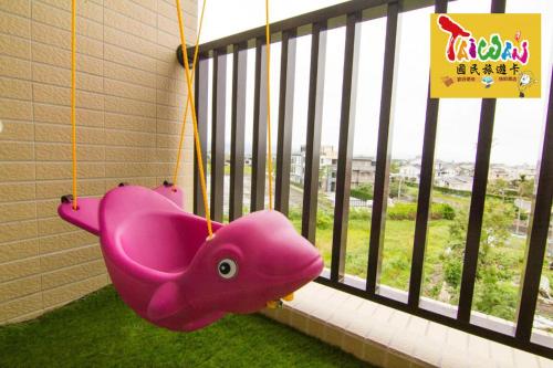 a pink pig swing in front of a window at 充電樁 羅東木村電梯民宿Luodong Tree BnB 雲朵朵二館 近週三清溝 免費洗衣機 烘衣機 星巴克咖啡豆 國旅卡特約店 in Luodong