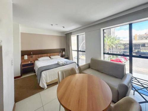 Un dormitorio con una cama, una mesa y un sofá. en Alugueasy - Hotel Athos Bulcão, en Brasilia