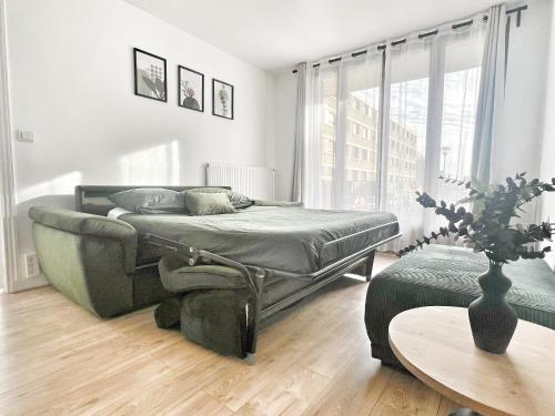 Un dormitorio con una cama y una mesa. en Appartement proche Roissy CDG, Parc expos de Villepinte, Disneyland, Paris, Astérix, en Le Thillay