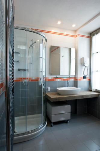 a bathroom with a glass shower and a sink at Residence Hotel Serenella in Aprica