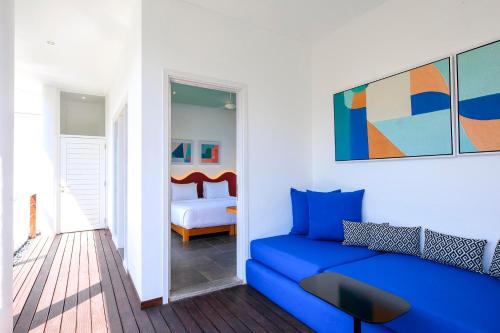 a blue couch in a room with a bedroom at Villa Ungava in Seminyak
