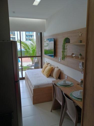 a bedroom with a bed and a table and a dining room at Makia Beach Experience # Flat Térreo B-019 in Porto De Galinhas