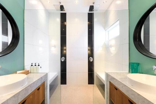 a bathroom with two sinks and a shower at Villa Ungava in Seminyak