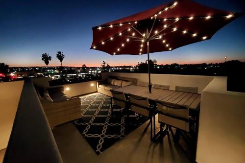 a rooftop patio with an umbrella and lights at Modern comfort, prime location, 360 views, 4 BR entire house in San Diego