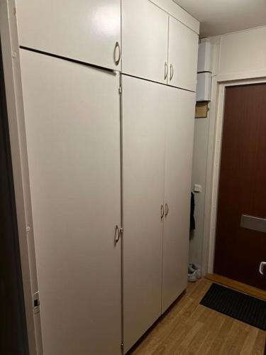 una cucina con armadi bianchi e una porta per una camera di Comfort zone a Stoccolma