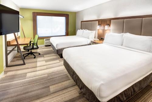 a hotel room with two beds and a desk at Holiday Inn Express Woodbridge by IHG in Avenel