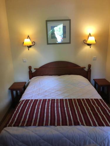 - une chambre avec un lit et deux lampes murales dans l'établissement 1-Appt avec piscine à St-Jean Pays-Basque, à Uhart-Cize