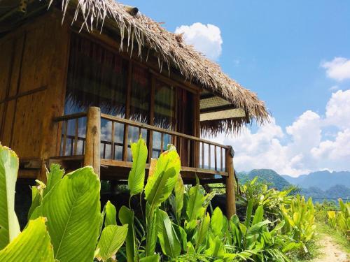 a hut with a deck in front of a field at Pu Luong Cuisine Garden Homestay in Làng Bang