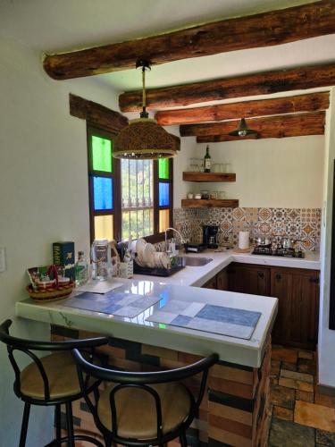 a kitchen with a table and two chairs and a counter at Hospedaje Resguardo Real in Ráquira