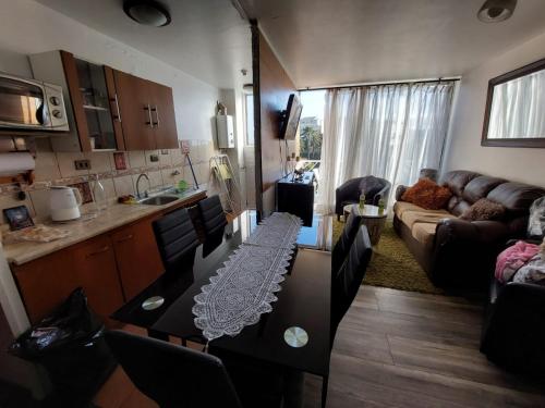 Departamento valpo في فالبارايسو: مطبخ وغرفة معيشة مع أريكة وطاولة