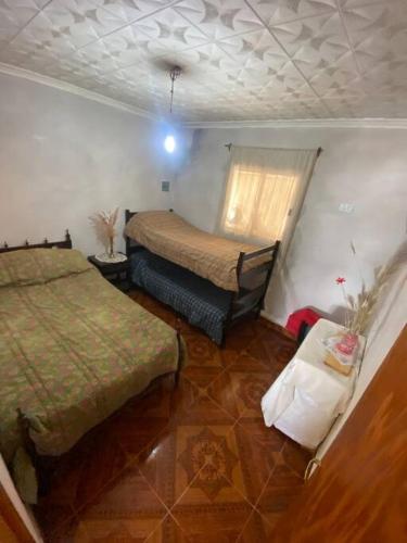 a small bedroom with two beds and a table at Casa en la montaña con gran vista al valle y lago in El Mollar