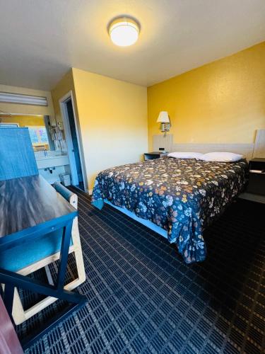 a hotel room with a bed and a yellow wall at Mount Whitney Motel in Lone Pine