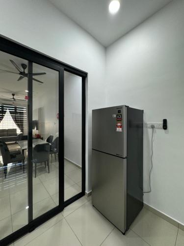 a stainless steel refrigerator in a room with a dining room at 9 Homestay - Feel like home . in Muar