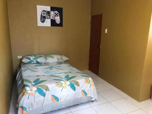 a bedroom with a bed with a camera on the wall at 1 Bedroom Apartment in Curepe