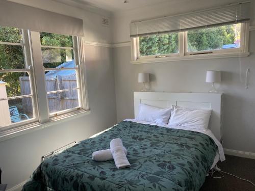 a bedroom with a bed with two towels on it at Blackheath Holiday Cabins in Blackheath