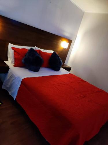 a bedroom with a red and white bed with red pillows at Departamentos Santiago in Santiago