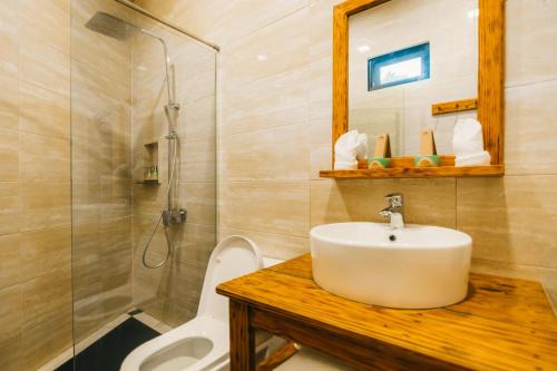 La salle de bains est pourvue d'un lavabo, d'une douche et de toilettes. dans l'établissement de Bintan Villa, à Tenaga
