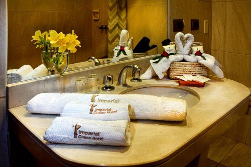 a bathroom counter with towels on a sink at IMPERIAL CUSCO HOTEL in Cusco