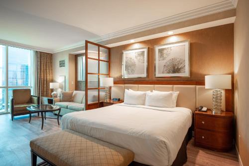 una camera d'albergo con un grande letto e una sedia di No Resort Fee Strip View Suite + Free Valet + Pool a Las Vegas