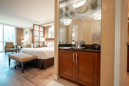 a bedroom with a bed and a kitchen with a sink at No Resort Fee Strip View Suite + Free Valet + Pool in Las Vegas