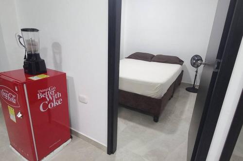 Zimmer mit einer Cola-Maschine neben einem Bett in der Unterkunft Apartamento central y tranquilo in Palmira