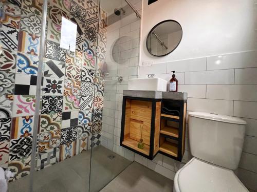 uma casa de banho com um WC, um lavatório e um espelho. em Casa hotel Los Laureles em Medellín