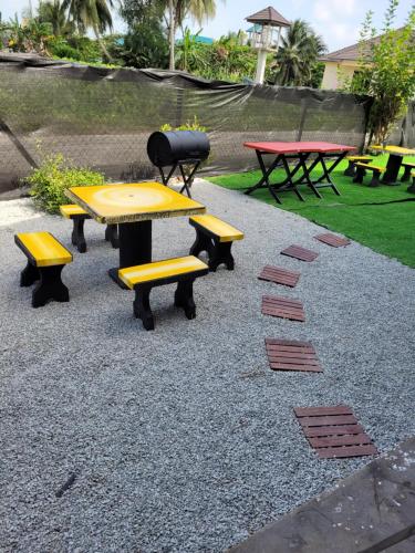 a group of picnic tables and benches in a park at BKB Homestay Kolam Bajet Bachok Kelantan in Bachok