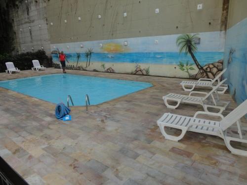 een zwembad met stoelen en een persoon die er naast staat bij Apart-Hotel Praia de Copacabana in Rio de Janeiro